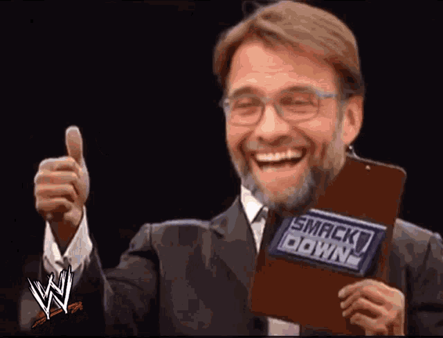 a man is holding a clipboard that says smack down