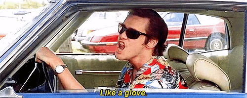 a man wearing sunglasses is singing while driving a car with the words like a glove below him