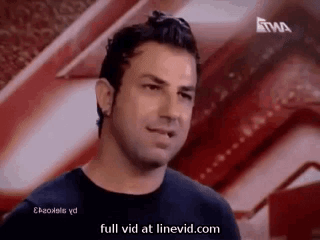 a man is standing in front of a red wall with the words full vid at linevid.com on the bottom