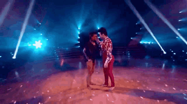 a man and a woman are dancing on a stage in front of a crowd .