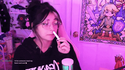 a girl sitting in front of a purple wall with a drawing of link on it