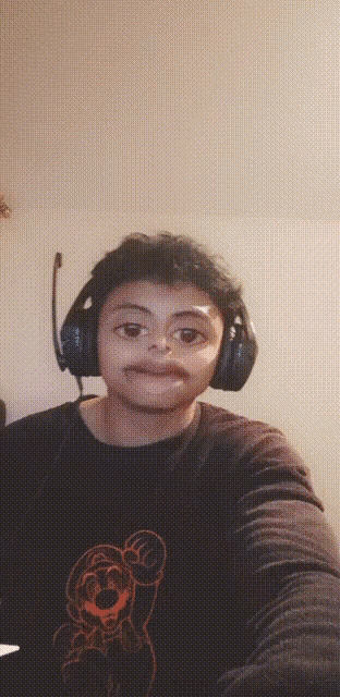 a young boy wearing headphones and a shirt with a mario on it