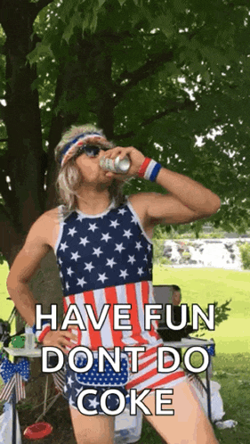 a man in an american flag outfit drinks from a can