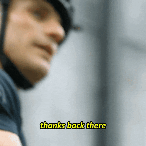a man wearing a helmet says " thanks back there " in yellow letters