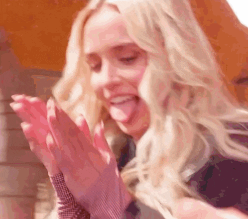 a close up of a woman making a funny face with her tongue out