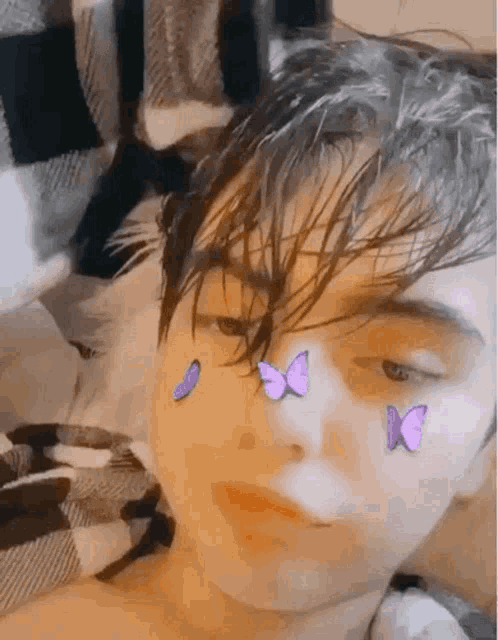 a close up of a person 's face with butterflies on it .