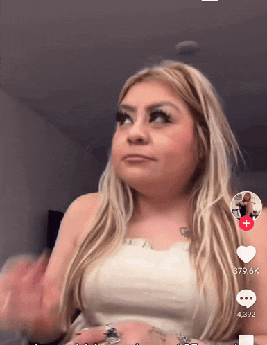 a woman in a white top has a tattoo of a heart on her arm