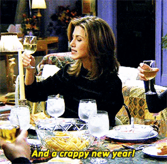 a woman sitting at a table holding a glass of wine with the words and a crappy new year