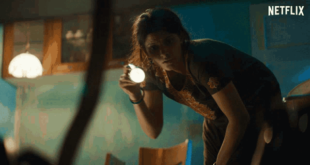 a woman is holding a flashlight in front of a netflix sign
