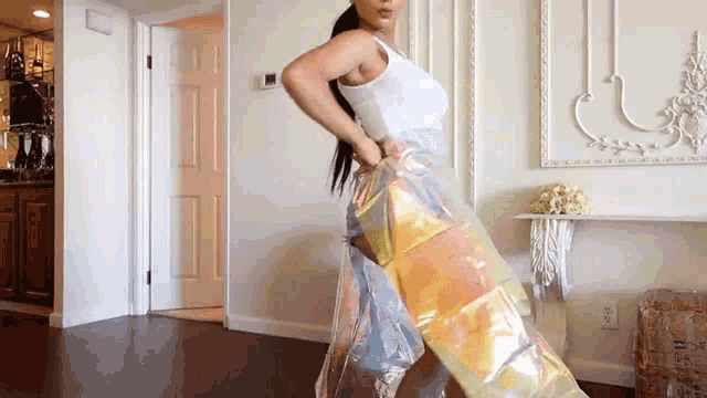 a woman in a white tank top is standing in a hallway