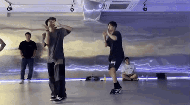 a group of young men are dancing together in a dance studio .