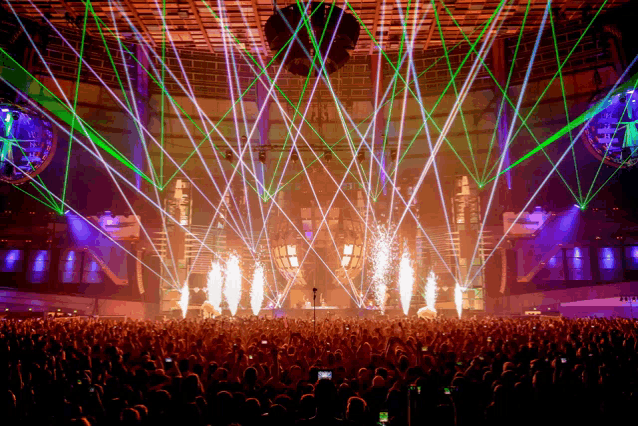a crowd of people are watching a concert with a lot of lights and fireworks