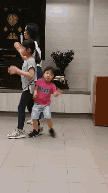a little girl in a pink shirt that says " lol " is dancing