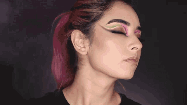a close up of a woman 's face with colorful makeup