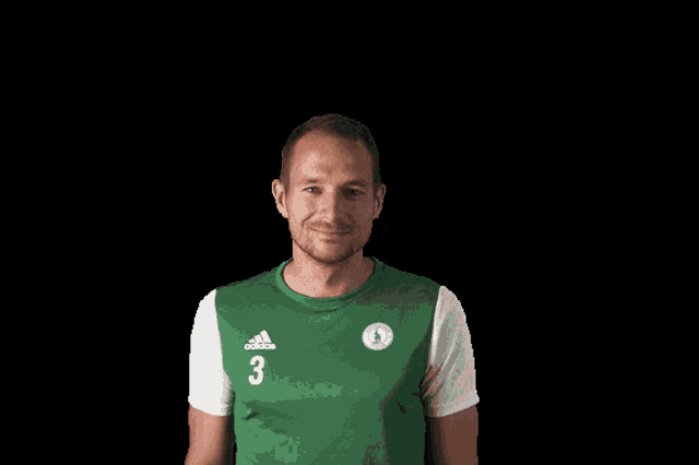a man in a green and white adidas shirt