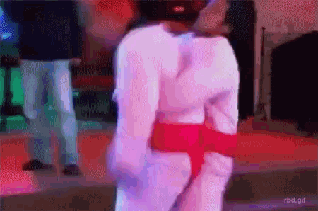 a gif of a person dancing with a red belt