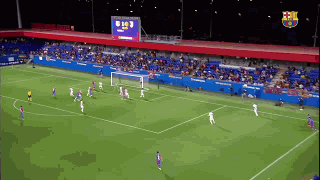 a soccer game is being played in front of a crowd and a scoreboard that says fc barcelona