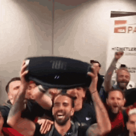a group of people are holding up a jbl speaker .
