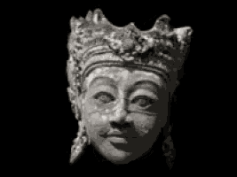 a black and white photo of a statue of a demon 's face .