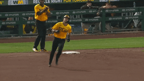 a baseball player wearing a yellow shirt that says pgh is running on the field