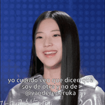 a woman with long black hair is smiling in front of a blue background