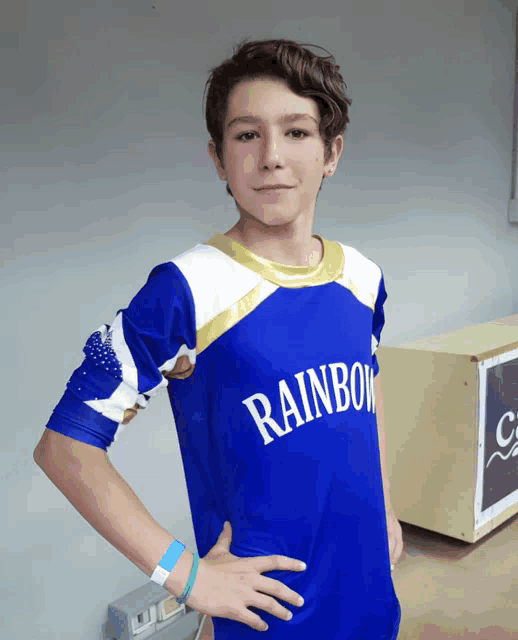 a boy wearing a blue and white rainbow shirt