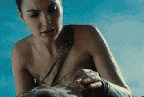 a woman without a shirt is holding something in her hand against a blue sky