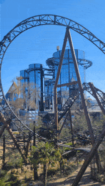 a roller coaster in an amusement park with a blue sky in the background