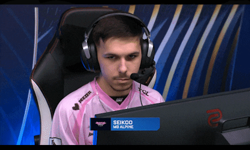 a man wearing headphones and a pink shirt with the name seikoo on the screen