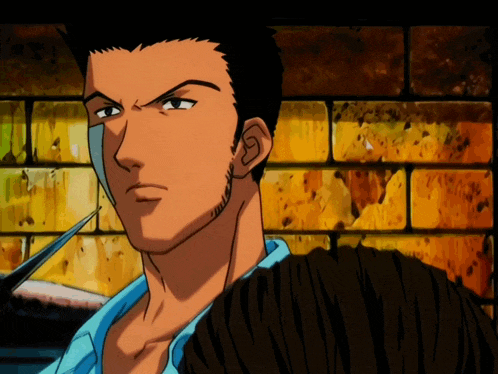 a man in a blue shirt is standing in front of a yellow brick wall