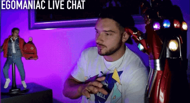 a man sitting in front of a purple wall with the words egomaniac live chat