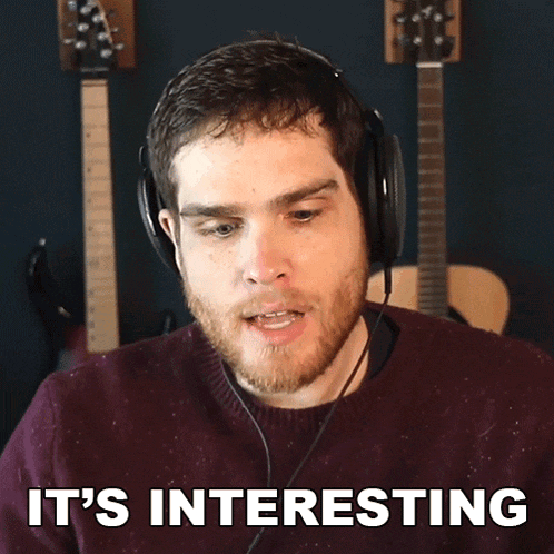 a man wearing headphones says " it 's interesting " in front of guitars