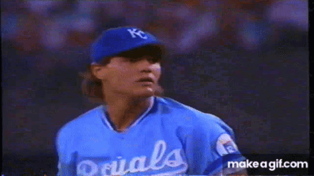 a baseball player wearing a kc hat and glove is getting ready to throw the ball