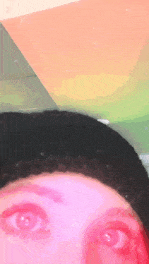 a close up of a person 's eyes with a rainbow in the background
