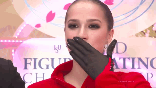 a woman in a red jacket covering her mouth with her hand