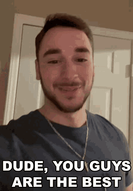 a man with a beard stands in front of a door with the words dude you guys are the best above him