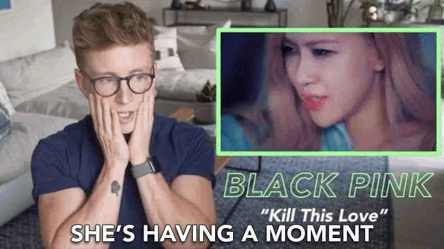a man with glasses is watching a video of black pink