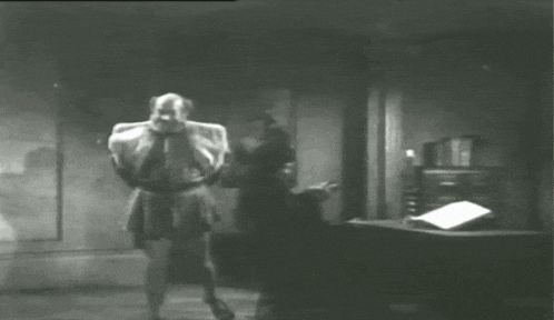 a black and white photo of a man walking in a room