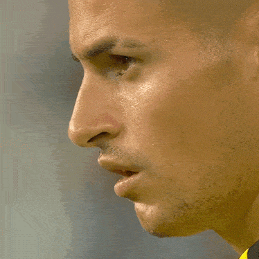 a close up of a man 's face in a yellow and black shirt