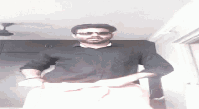 a man wearing sunglasses and a black shirt is dancing