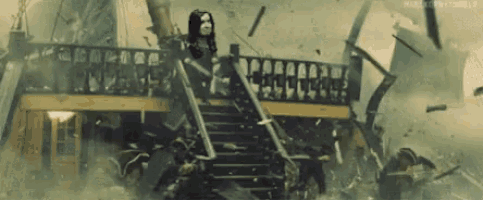 a woman is standing on top of a staircase on a pirate ship .