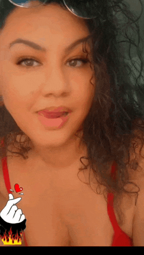 a woman with curly hair is wearing a red bra