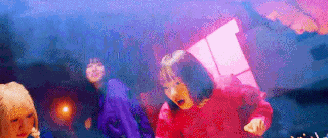 a group of girls are dancing together in a room with a purple background .