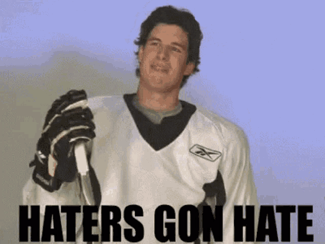 a hockey player is holding a stick with the words haters gon hate behind him