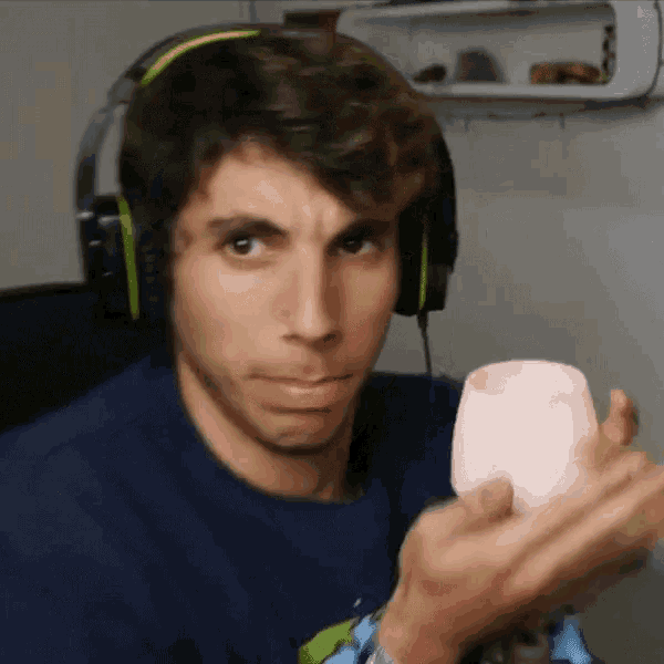 a man wearing headphones is holding a white cup