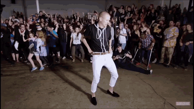 a man is dancing in front of a crowd with the word subscribe on the bottom