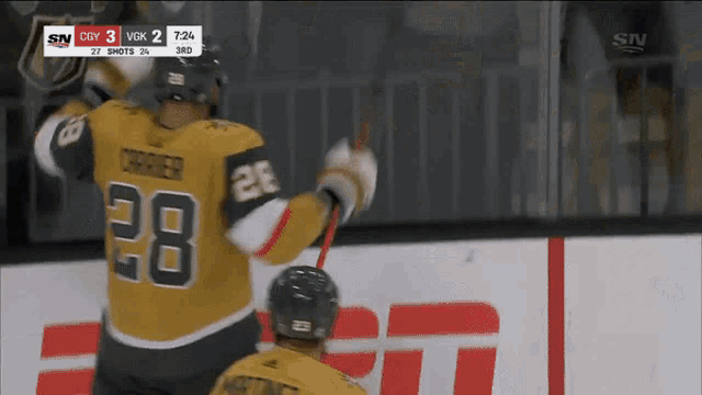 a hockey player with the number 28 on his jersey celebrates