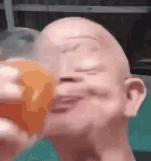a close up of a bald man drinking orange juice