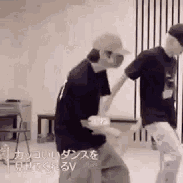 a couple of men are standing next to each other in a room and dancing .