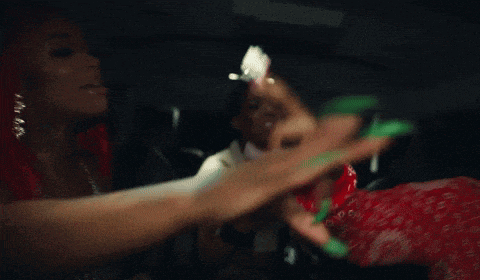 a woman in a red bandana is holding a green toy and a bunch of money .